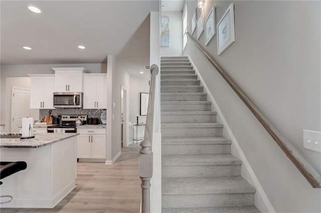 staircase featuring wood-type flooring