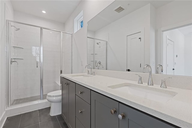 bathroom with a shower with shower door, vanity, tile patterned flooring, and toilet