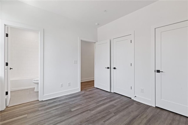 unfurnished bedroom featuring light wood-type flooring, a closet, and connected bathroom