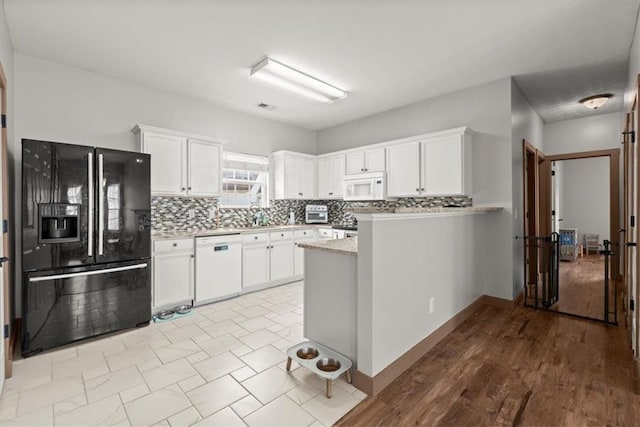 kitchen featuring backsplash, sink, white cabinets, and white appliances