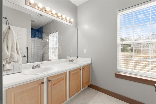 bathroom with vanity, a healthy amount of sunlight, and walk in shower