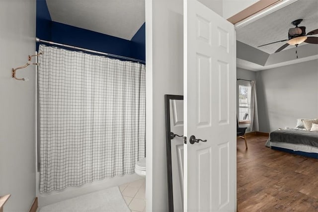 bathroom with wood-type flooring, toilet, and ceiling fan