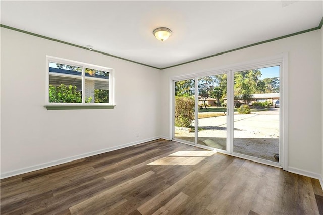 spare room featuring crown molding and dark hardwood / wood-style floors