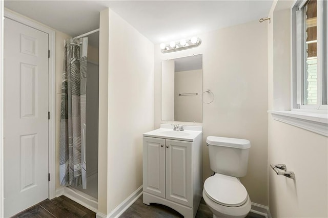 bathroom with a shower with shower curtain, hardwood / wood-style floors, vanity, and toilet