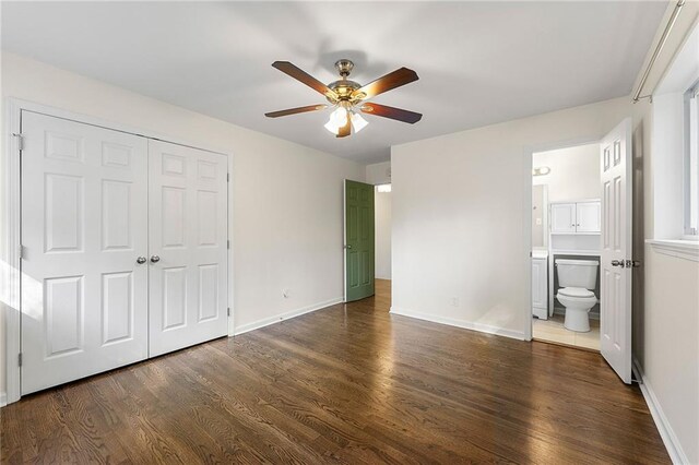 unfurnished bedroom with ceiling fan, a closet, dark wood-type flooring, and ensuite bath