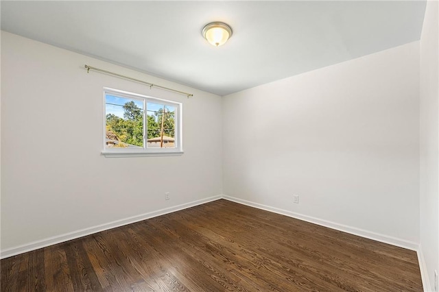 empty room with dark hardwood / wood-style flooring