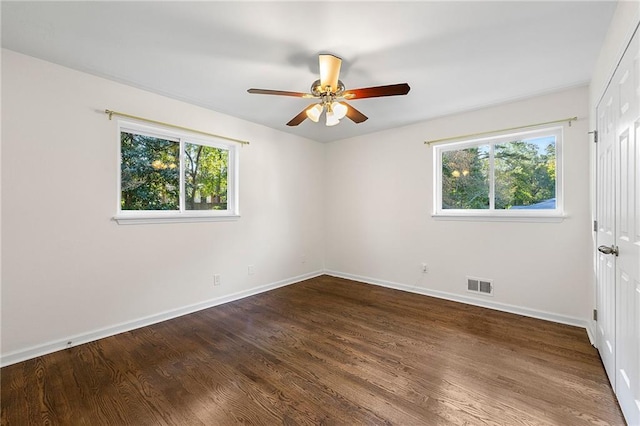 empty room featuring ceiling fan, plenty of natural light, and hardwood / wood-style floors