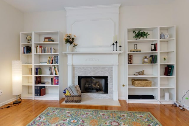 living room featuring a fireplace with flush hearth and wood finished floors