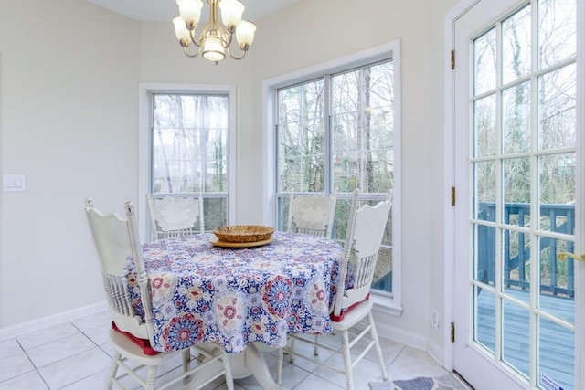 tiled dining area featuring baseboards, plenty of natural light, and a chandelier