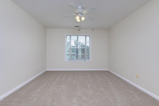 carpeted empty room featuring visible vents, baseboards, and ceiling fan