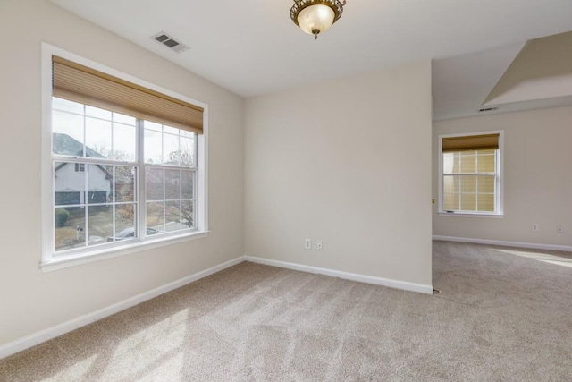 carpeted empty room with visible vents and baseboards