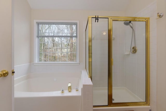 bathroom featuring a shower stall and a bath