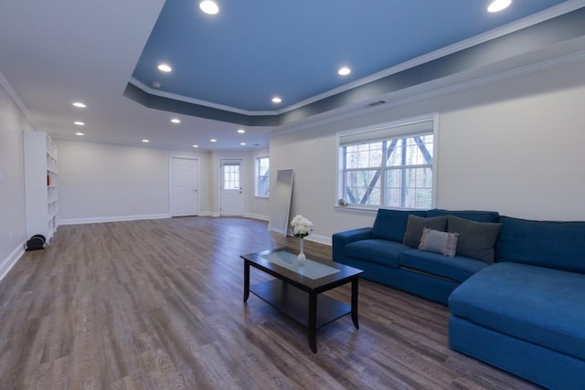 living room with crown molding, baseboards, a tray ceiling, recessed lighting, and wood finished floors