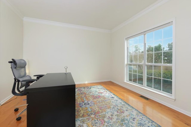 office featuring light wood-type flooring, baseboards, visible vents, and ornamental molding