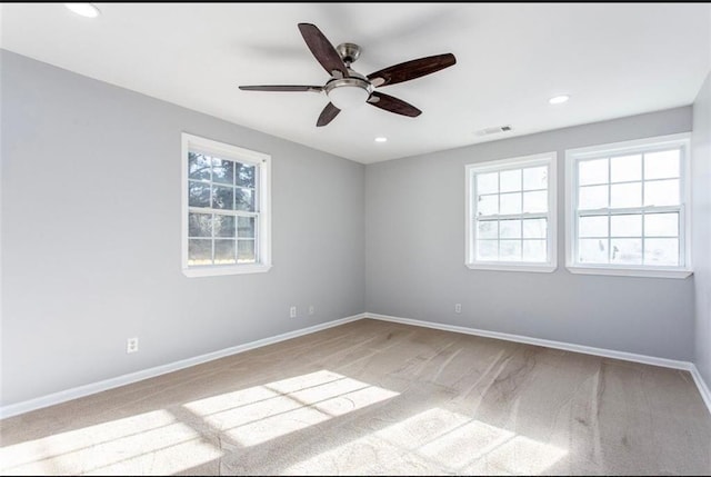 carpeted spare room featuring ceiling fan