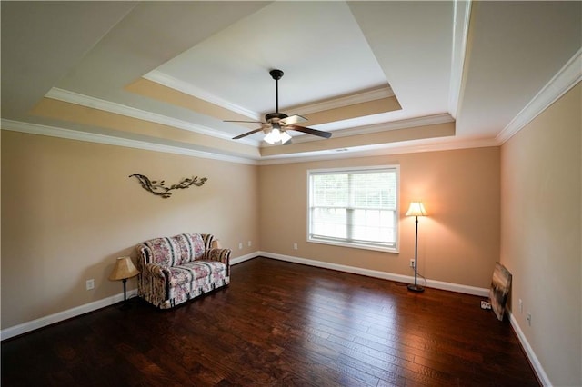 unfurnished room with a raised ceiling, ceiling fan, wood-type flooring, crown molding, and baseboards