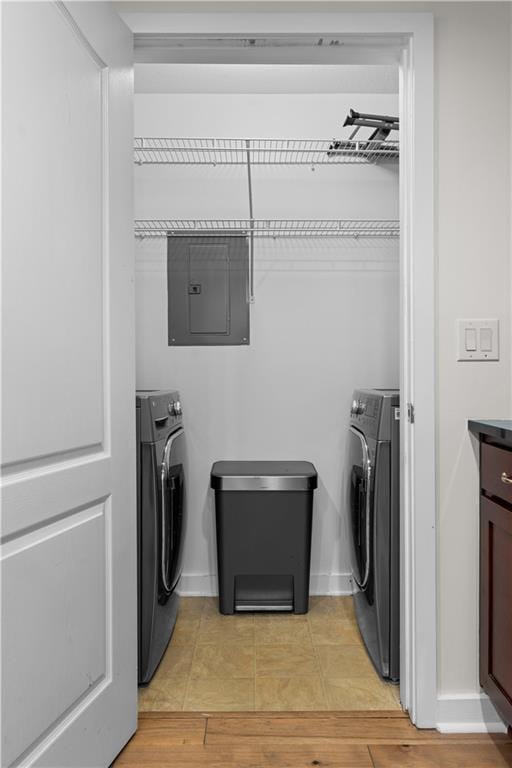 laundry room featuring electric panel, light tile patterned floors, washer / clothes dryer, and baseboards