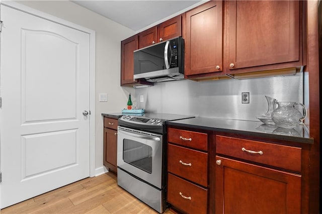 kitchen featuring dark countertops, stainless steel appliances, and light wood-style floors