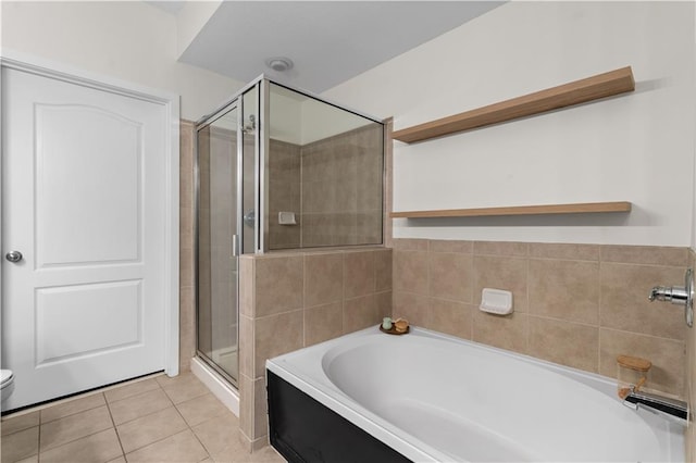 bathroom featuring toilet, tile patterned floors, a garden tub, and a stall shower