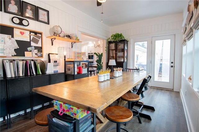 dining space featuring wood walls and dark hardwood / wood-style floors