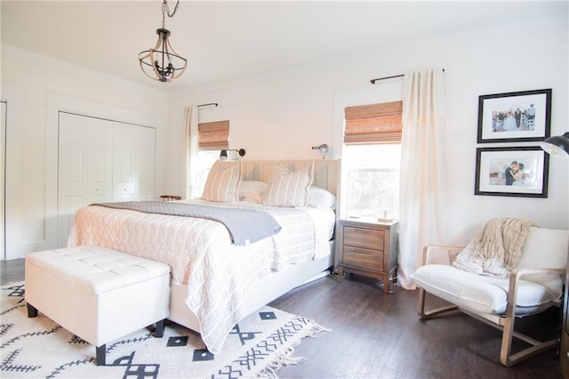 bedroom featuring an inviting chandelier, a closet, and dark hardwood / wood-style floors