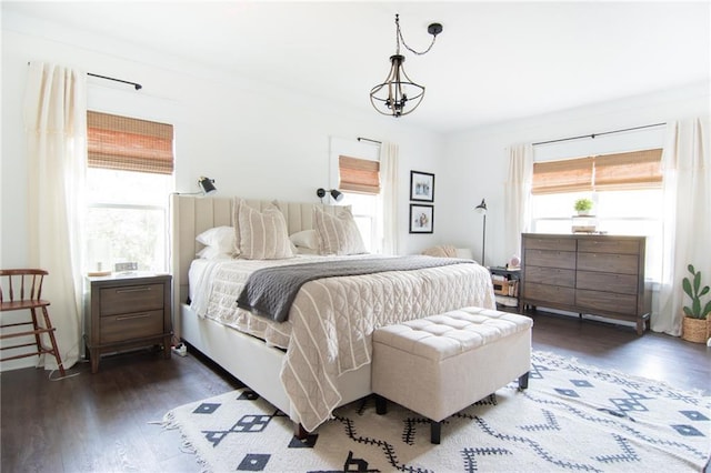 bedroom with dark wood-type flooring and a notable chandelier