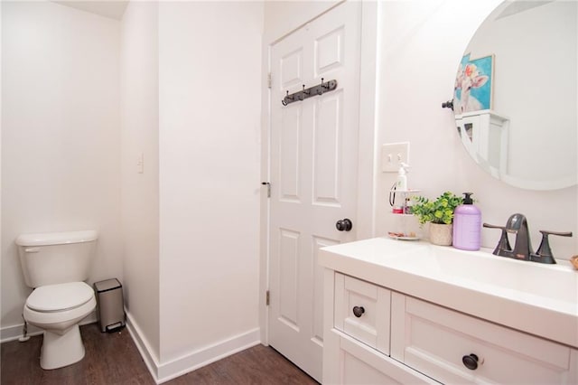 bathroom with hardwood / wood-style flooring, vanity, and toilet