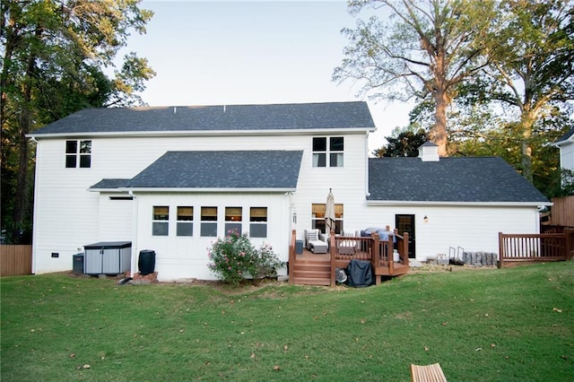 back of property with a wooden deck and a lawn