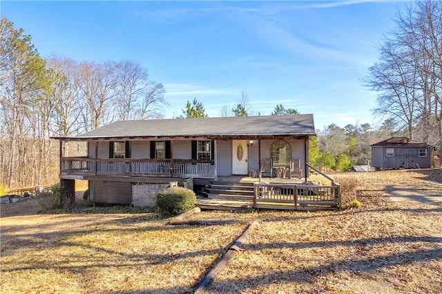 view of front of property with a porch, an outdoor structure, and a shed