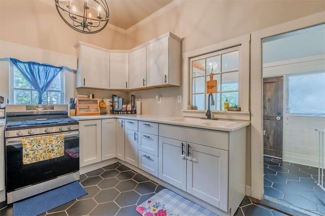 229 Slate St, Rockmart, GA 30153 - kitchen with stainless steel gas range oven, a sink, light countertops, a chandelier, and ornamental molding