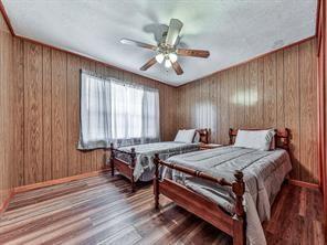 6267 Mount Pisgah Rd, Ellijay, GA 30540 - bedroom with wooden walls, ceiling fan, and wood finished floors