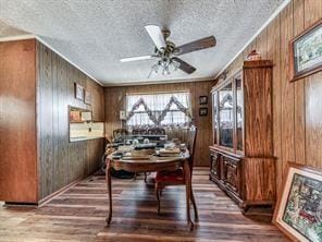 6267 Mount Pisgah Rd, Ellijay, GA 30540 - dining area with wooden walls, a textured ceiling, a ceiling fan, and light wood-style floors