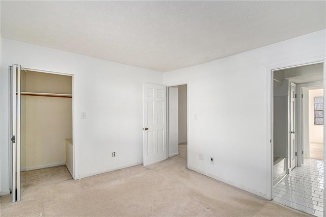 unfurnished bedroom featuring light carpet and a textured ceiling