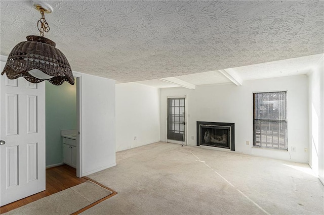 unfurnished living room featuring a wealth of natural light, carpet, a fireplace, and a textured ceiling