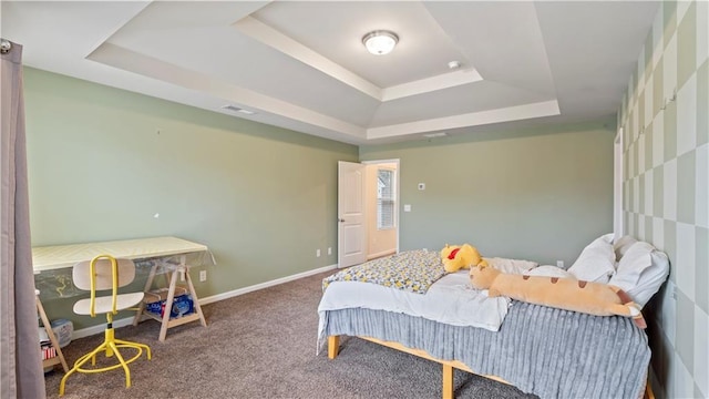 carpeted bedroom with baseboards, visible vents, and a tray ceiling