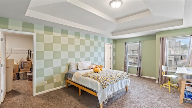 carpeted bedroom with a tray ceiling and wallpapered walls