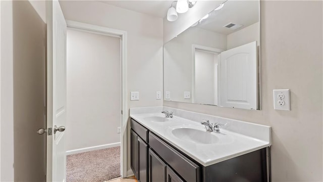 bathroom with visible vents, a sink, baseboards, and double vanity