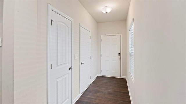 hallway featuring dark wood-style floors and baseboards