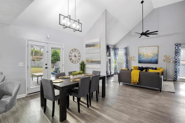 dining area with plenty of natural light, high vaulted ceiling, wood finished floors, and french doors