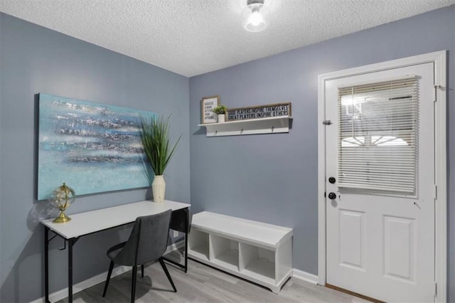 office with a textured ceiling, wood finished floors, and baseboards