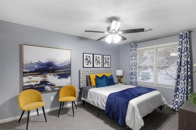 bedroom with a textured ceiling, carpet flooring, visible vents, and baseboards