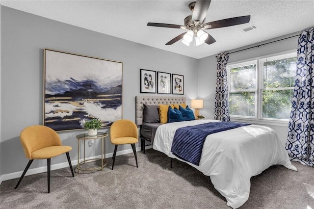 carpeted bedroom featuring a ceiling fan, baseboards, visible vents, and a textured ceiling