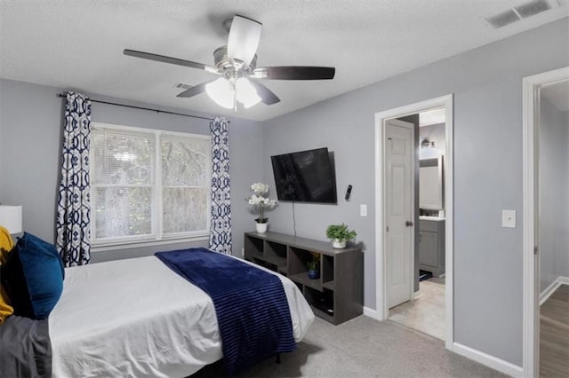 carpeted bedroom with a ceiling fan, baseboards, visible vents, and a textured ceiling