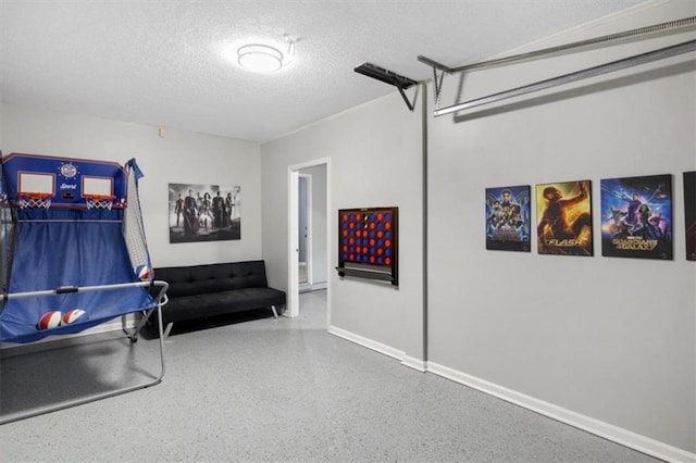 game room featuring a textured ceiling, speckled floor, a garage, and baseboards