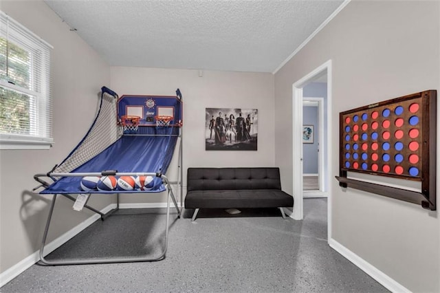 interior space featuring a textured ceiling, speckled floor, and baseboards