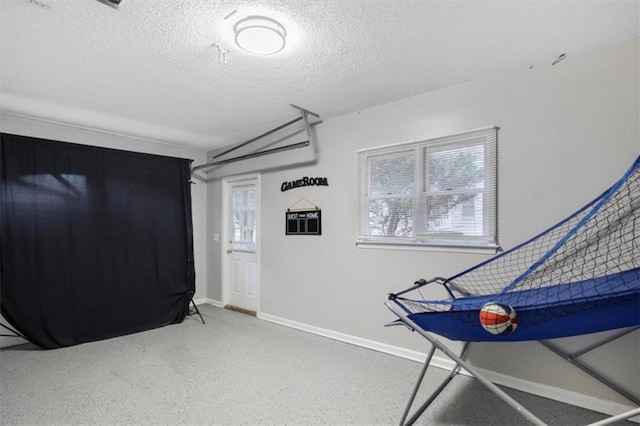 game room with a healthy amount of sunlight, baseboards, and a textured ceiling