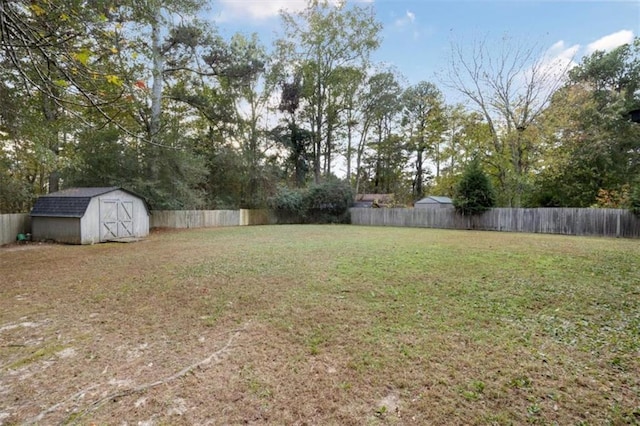 view of yard with an outbuilding, a shed, and a fenced backyard