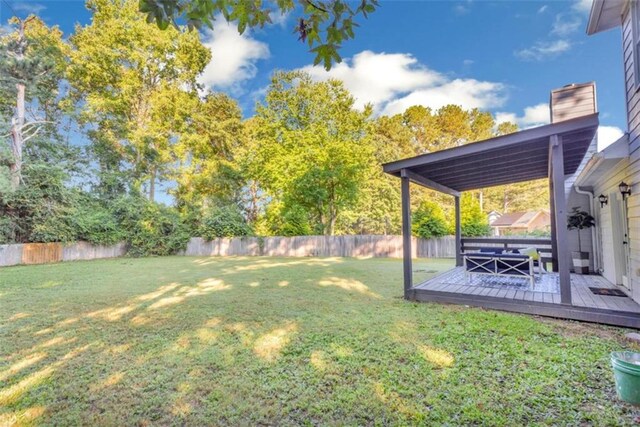 view of yard with a fenced backyard and a wooden deck