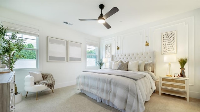 bedroom featuring multiple windows, light carpet, and baseboards