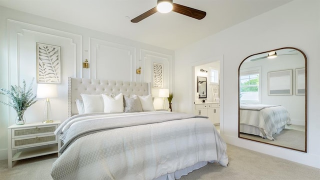 bedroom featuring carpet floors, ensuite bath, and a ceiling fan
